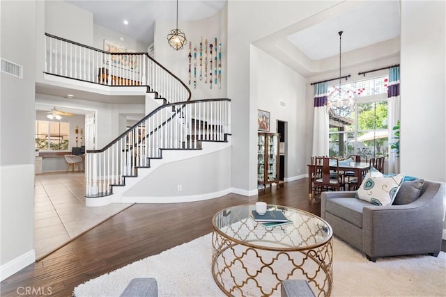 12475 Woodhall Way, Tustin, CA 92782 - living area with a chandelier, a high ceiling, stairs, wood finished floors, and baseboards