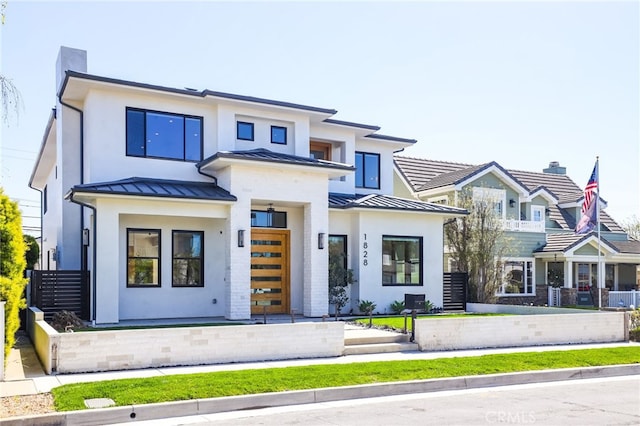 view of front of house with stucco siding, a standing seam roof, and metal roof