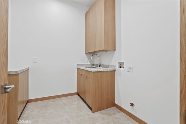 clothes washing area with a sink, cabinet space, baseboards, gas dryer hookup, and washer hookup