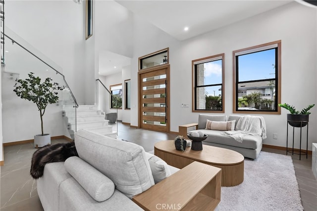 living area featuring recessed lighting, baseboards, and stairs