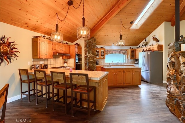 40957 Shandee Ln, Ahwahnee, CA 93601 - kitchen featuring glass insert cabinets, a peninsula, stainless steel appliances, dark wood-type flooring, and a skylight