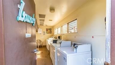 community laundry room featuring separate washer and dryer