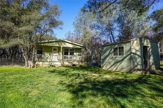 14134 Serpentine Farm Ln, Grass Valley, CA 95949 - back of house featuring a porch, an outdoor structure, and a lawn