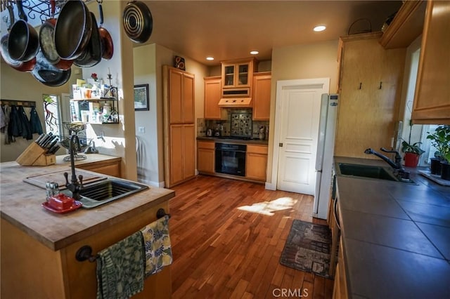 14134 Serpentine Farm Ln, Grass Valley, CA 95949 - kitchen with custom exhaust hood, oven, decorative backsplash, a sink, and wood finished floors