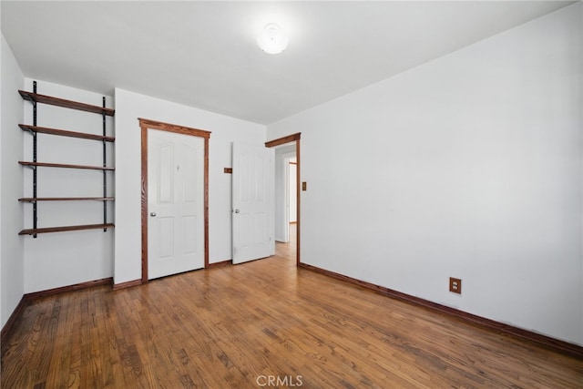 unfurnished bedroom with baseboards and wood finished floors