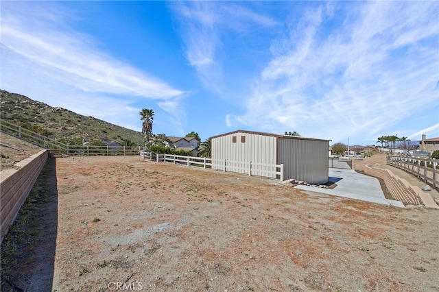 view of yard with fence and an outbuilding