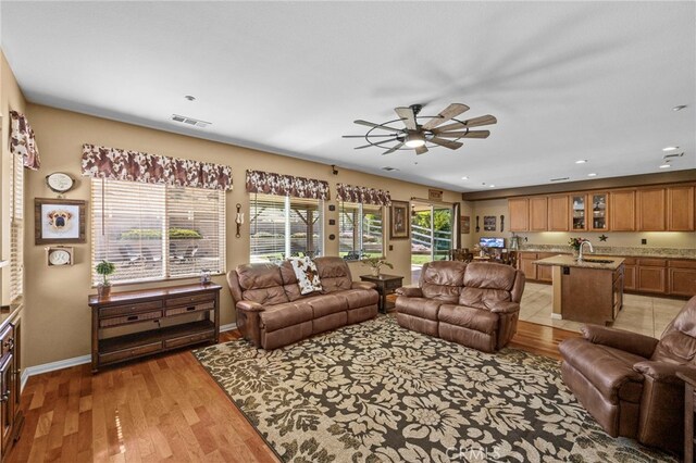living area featuring light wood-type flooring, ceiling fan, baseboards, visible vents, and recessed lighting