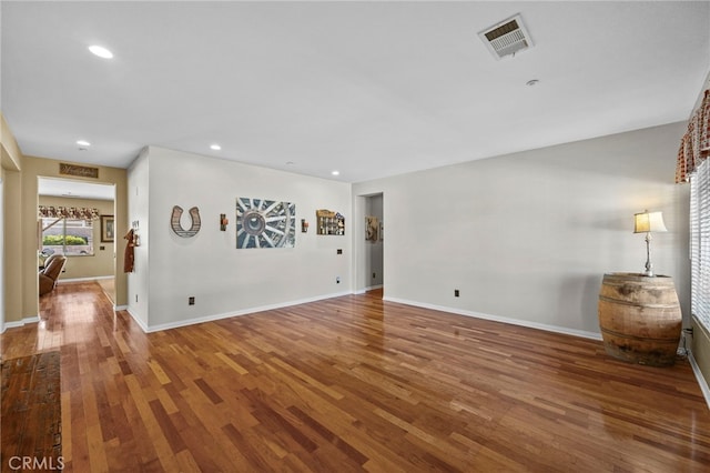 empty room with baseboards, wood finished floors, visible vents, and recessed lighting