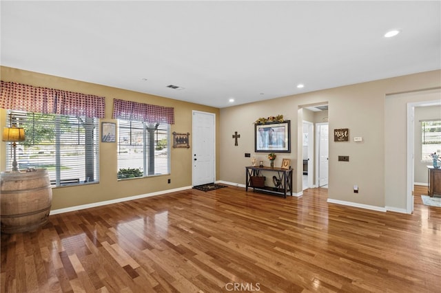 foyer entrance featuring light wood-style floors, visible vents, and baseboards
