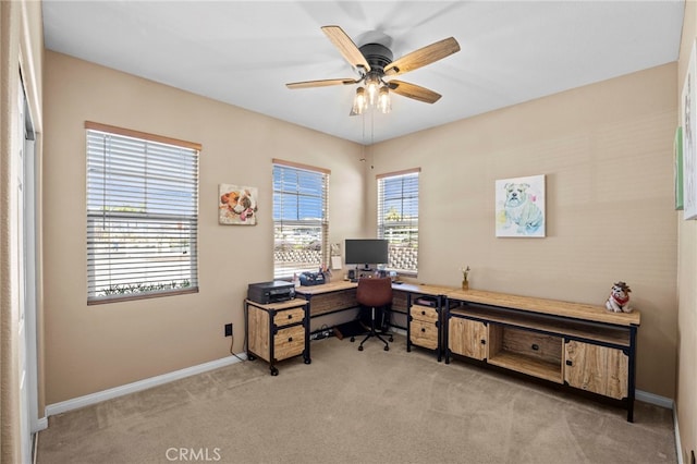 carpeted home office featuring baseboards and ceiling fan