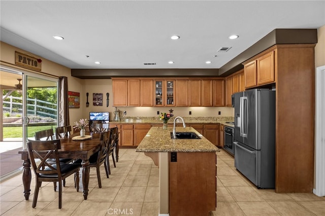 kitchen with brown cabinets, visible vents, stainless steel appliances, and a sink