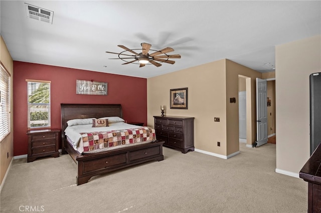 carpeted bedroom featuring baseboards, a ceiling fan, and visible vents