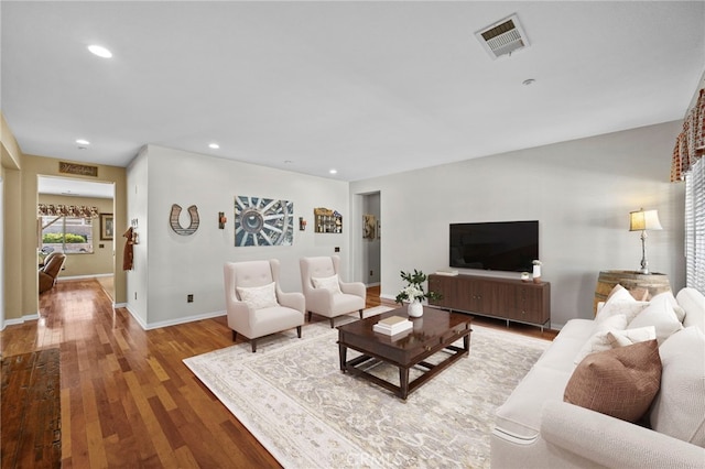living area featuring baseboards, wood finished floors, visible vents, and recessed lighting