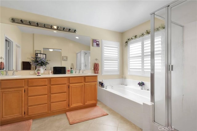 bathroom featuring a garden tub, a shower stall, a sink, tile patterned floors, and double vanity