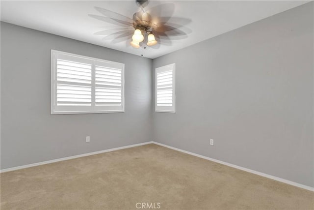 empty room with carpet flooring, ceiling fan, and baseboards