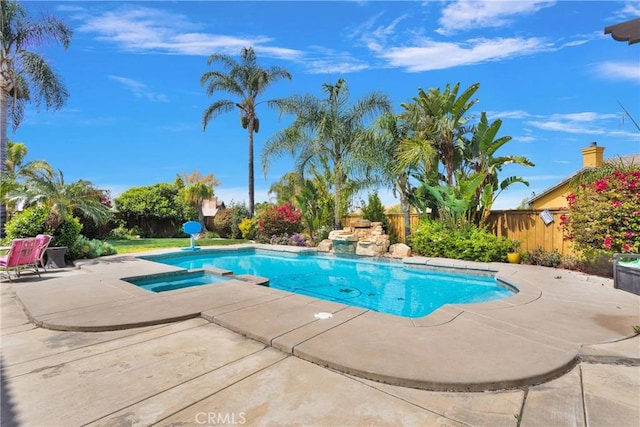 view of pool with a patio area, a pool with connected hot tub, and fence