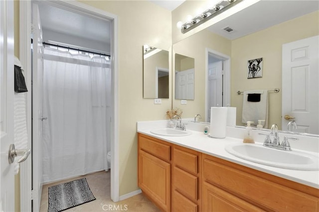 bathroom with tile patterned floors, double vanity, visible vents, and a sink