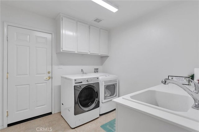 clothes washing area with cabinet space, visible vents, light tile patterned flooring, a sink, and washing machine and dryer