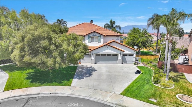 view of front of house with concrete driveway, an attached garage, a front yard, a tiled roof, and fence
