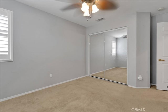 unfurnished bedroom with visible vents, a closet, baseboards, and carpet floors