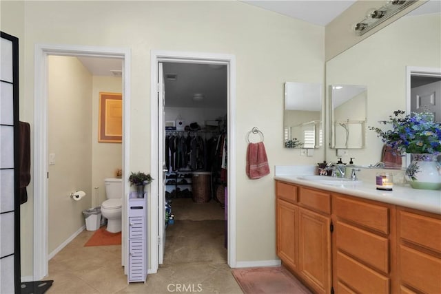 bathroom with tile patterned floors, toilet, vanity, and baseboards