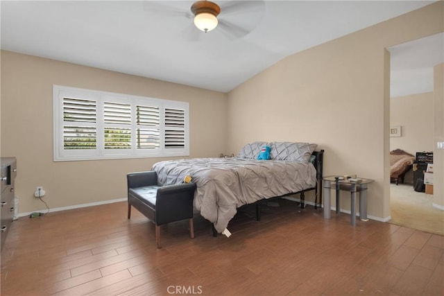 bedroom featuring wood finished floors, ceiling fan, baseboards, and lofted ceiling