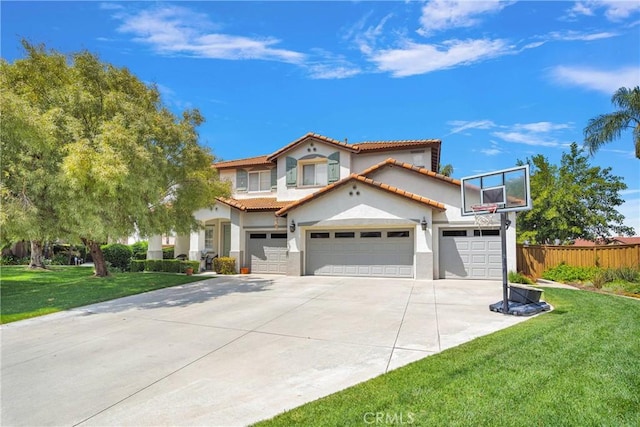 mediterranean / spanish home with a front yard, driveway, a tiled roof, and stucco siding