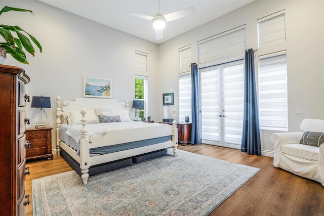 bedroom featuring light wood-style floors, a ceiling fan, baseboards, and access to exterior