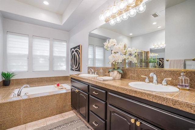 bathroom featuring a sink, tile patterned floors, a garden tub, and visible vents