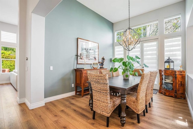 dining area with baseboards, a chandelier, a healthy amount of sunlight, and light wood-type flooring