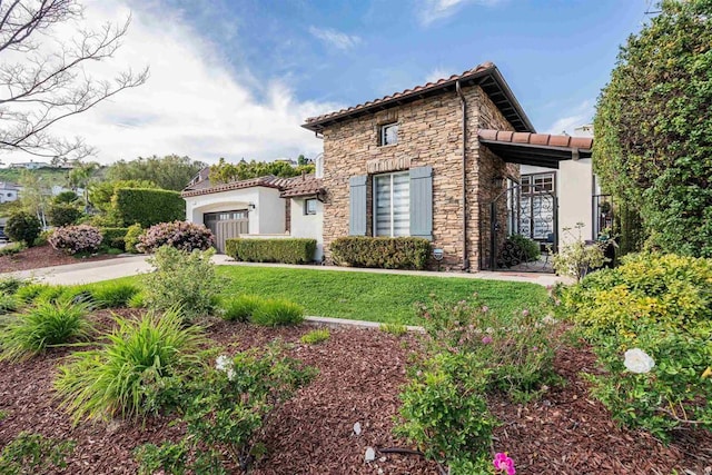 view of front of property with a garage, stucco siding, a tiled roof, and stone siding