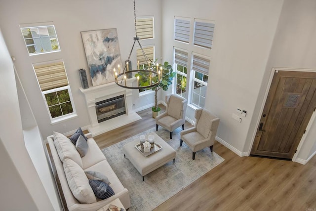 2463 Springbrook St, Thousand Oaks, CA 91362 - living room with wood finished floors, a chandelier, a high ceiling, and a glass covered fireplace