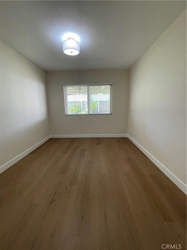 unfurnished room featuring wood finished floors and baseboards