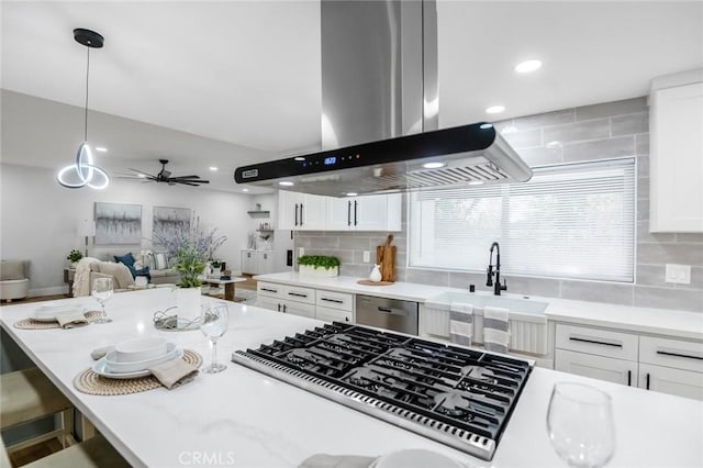 kitchen featuring a sink, light countertops, white cabinetry, and island exhaust hood
