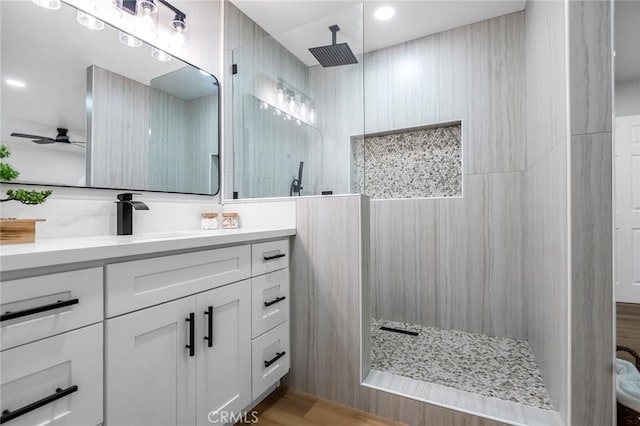 full bathroom featuring vanity, walk in shower, and a ceiling fan