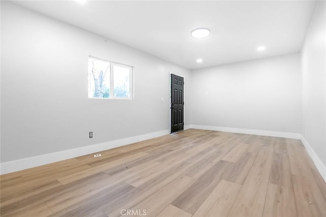 empty room with baseboards, recessed lighting, and light wood-style floors