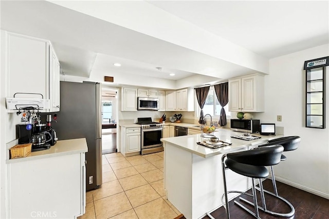 2842 Pietro Dr, Hacienda Heights, CA 91745 - kitchen with stainless steel appliances, a peninsula, light countertops, a kitchen breakfast bar, and recessed lighting