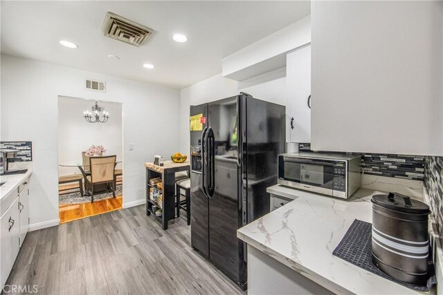 30993 Palo Alto Dr, Redlands, CA 92373 - kitchen with black refrigerator with ice dispenser, stainless steel microwave, light wood-style flooring, decorative backsplash, and a chandelier