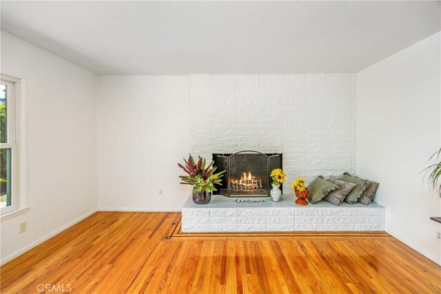 30993 Palo Alto Dr, Redlands, CA 92373 - unfurnished living room with wood finished floors, a brick fireplace, and baseboards
