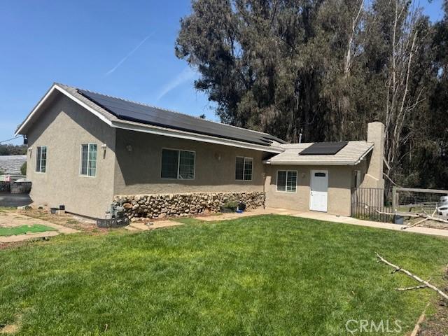 968 Calle Fresa, Nipomo, CA 93444 - back of property featuring stucco siding, roof mounted solar panels, and a chimney