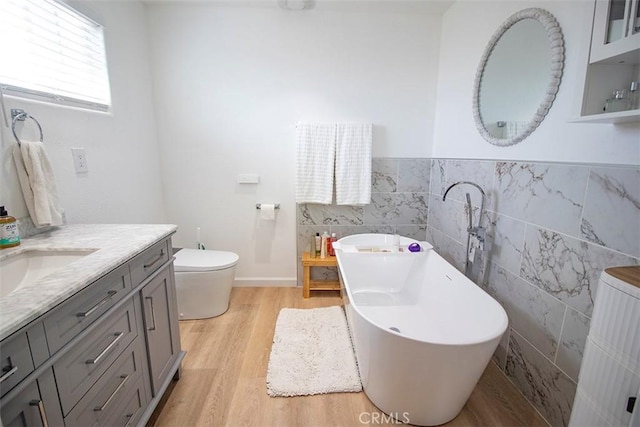 968 Calle Fresa, Nipomo, CA 93444 - bathroom with tile walls, vanity, a freestanding bath, wood finished floors, and toilet