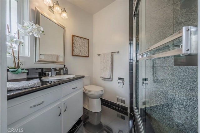bathroom featuring a shower stall, vanity, tile patterned flooring, visible vents, and toilet