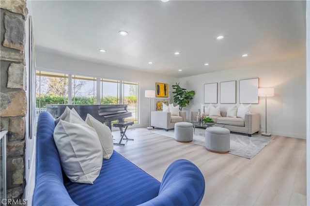 living room featuring wood finished floors, a fireplace, baseboards, and recessed lighting