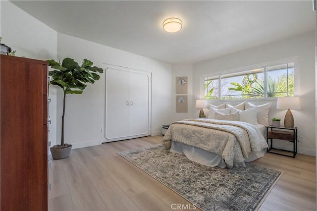 bedroom with light wood-type flooring and baseboards