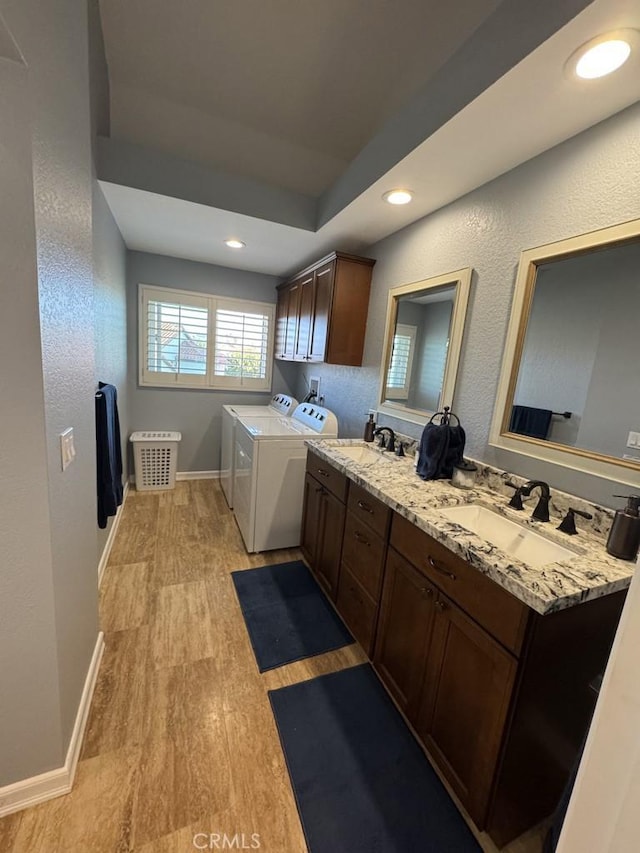 2244 Cannes Sq, Oxnard, CA 93035 - laundry room featuring light wood-style flooring, cabinet space, washing machine and dryer, recessed lighting, and a textured wall