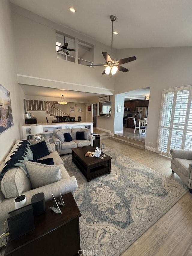 2244 Cannes Sq, Oxnard, CA 93035 - living room featuring a ceiling fan, high vaulted ceiling, baseboards, wood finished floors, and stairway