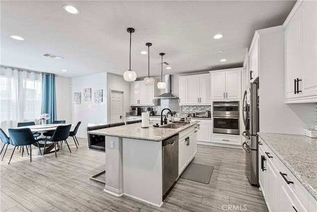 8794 Applewood St, Chino, CA 91708 - kitchen featuring tasteful backsplash, wall chimney range hood, white cabinetry, a sink, and stainless steel appliances