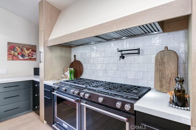 5385 N Van Ness Blvd, Fresno, CA 93711 - kitchen featuring double oven range, premium range hood, backsplash, light wood-type flooring, and light stone counters