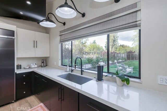 5385 N Van Ness Blvd, Fresno, CA 93711 - kitchen with a sink, refrigerator, light countertops, and white cabinetry