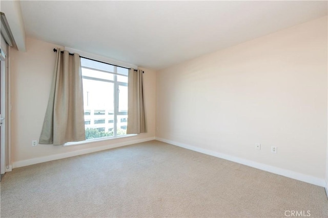 carpeted spare room featuring baseboards
